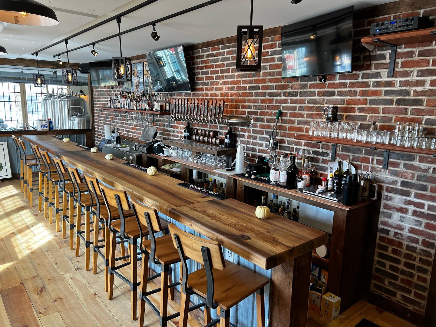 Bar and bar stools with draft beer taps behind the bar and liquor on display